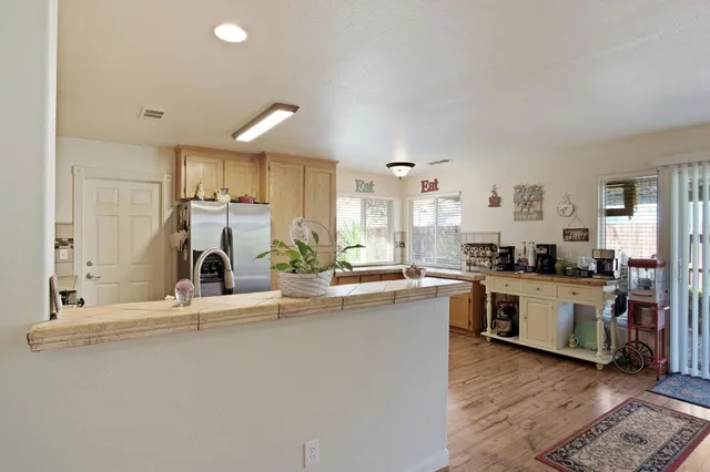 a kitchen with kitchen island granite countertop a sink cabinets and wooden floor