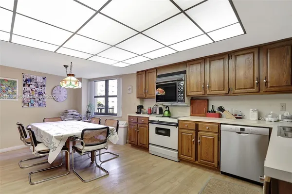 a large kitchen with stainless steel appliances granite countertop a lot of counter space and wooden floors
