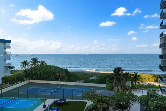 a view of a patio with a table and chairs under an umbrella