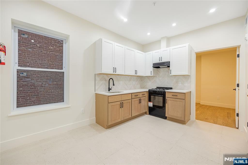 a kitchen with granite countertop white cabinets and white appliances
