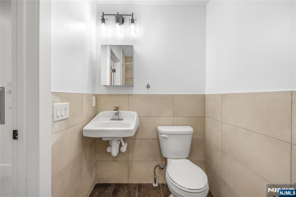 10 School Street, Unit 2 Passaic, NJ 07055 - Photo 6 of 11 a bathroom with a toilet sink and mirror
