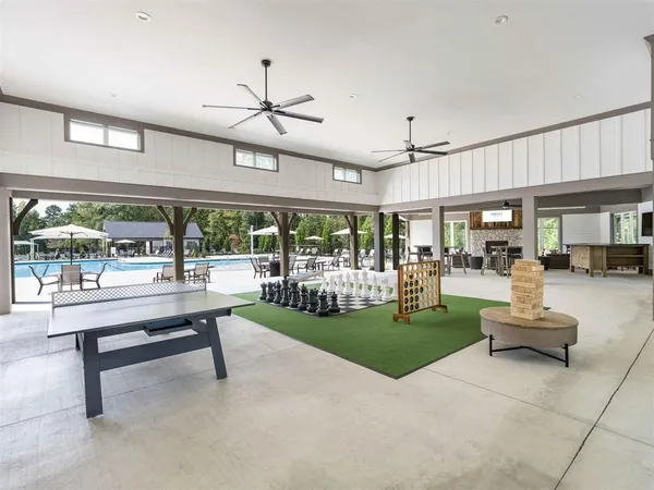 a living room with patio furniture and a floor to ceiling window