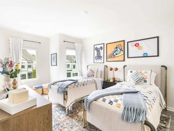 a bedroom with two beds and a large mirror next to a window