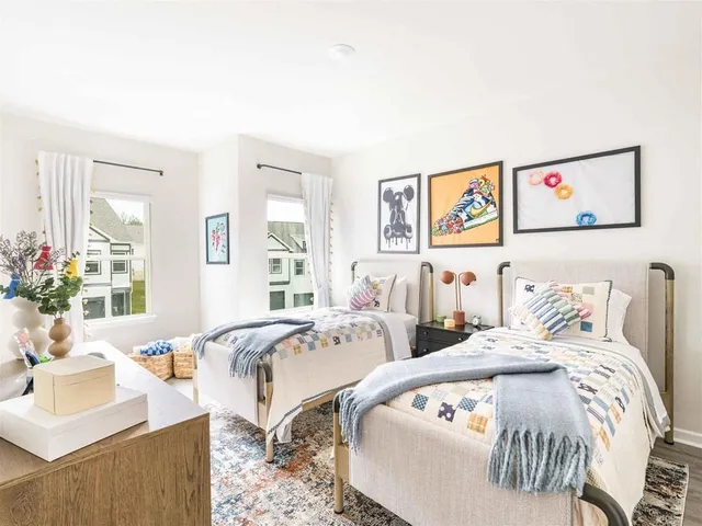 a bedroom with two beds and a large mirror next to a window