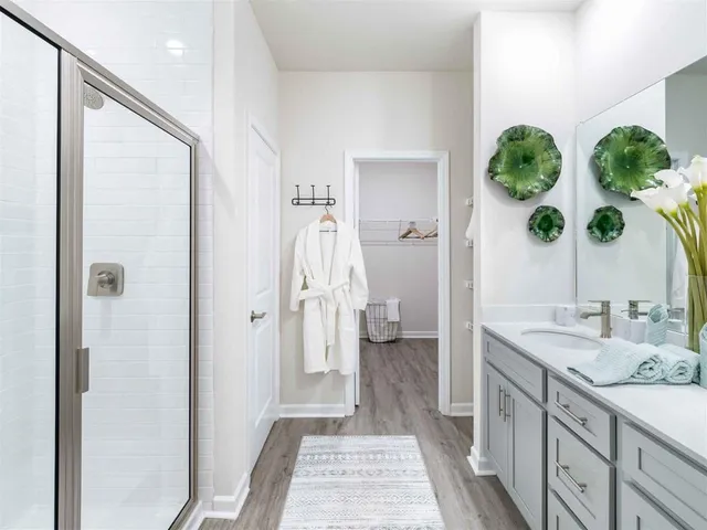 a spacious bathroom with a granite countertop sink a mirror and a shower
