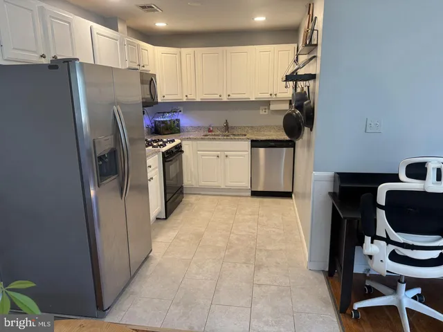 a kitchen with a refrigerator sink and cabinets
