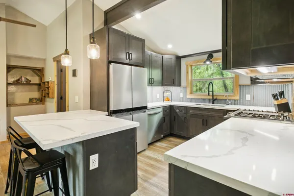 a kitchen with a sink a refrigerator and a stove top oven