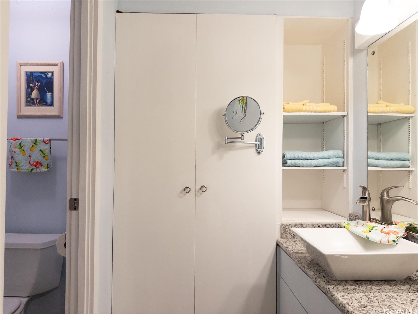 425 Ena Road, Unit 706B Honolulu, HI 96815 - Photo 14 of 23 a bathroom with a granite countertop sink a toilet and a shower