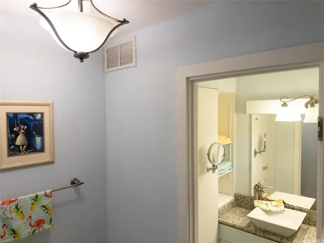 a bathroom with a granite countertop sink a mirror and a shower