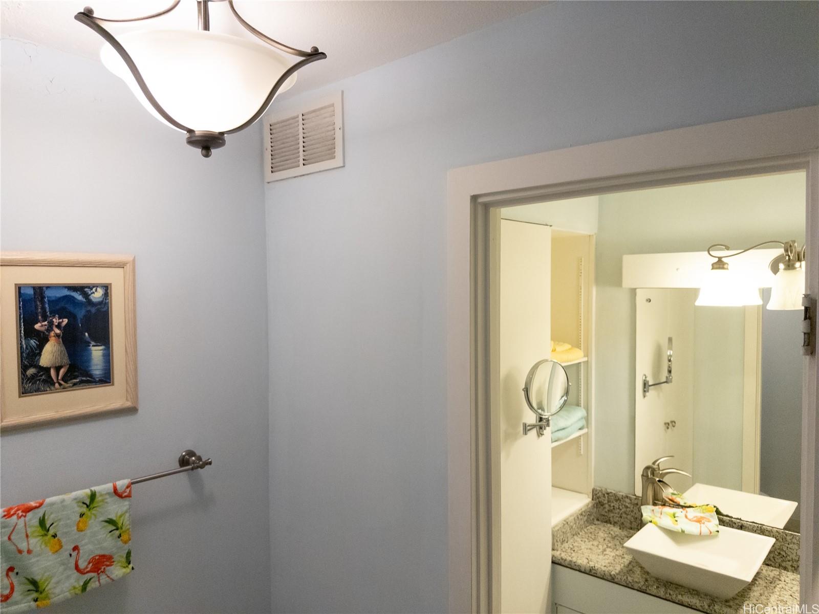 425 Ena Road, Unit 706B Honolulu, HI 96815 - Photo 15 of 23 a bathroom with a granite countertop sink a mirror and a shower
