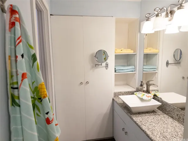 a bathroom with a granite countertop sink a toilet and shower curtain