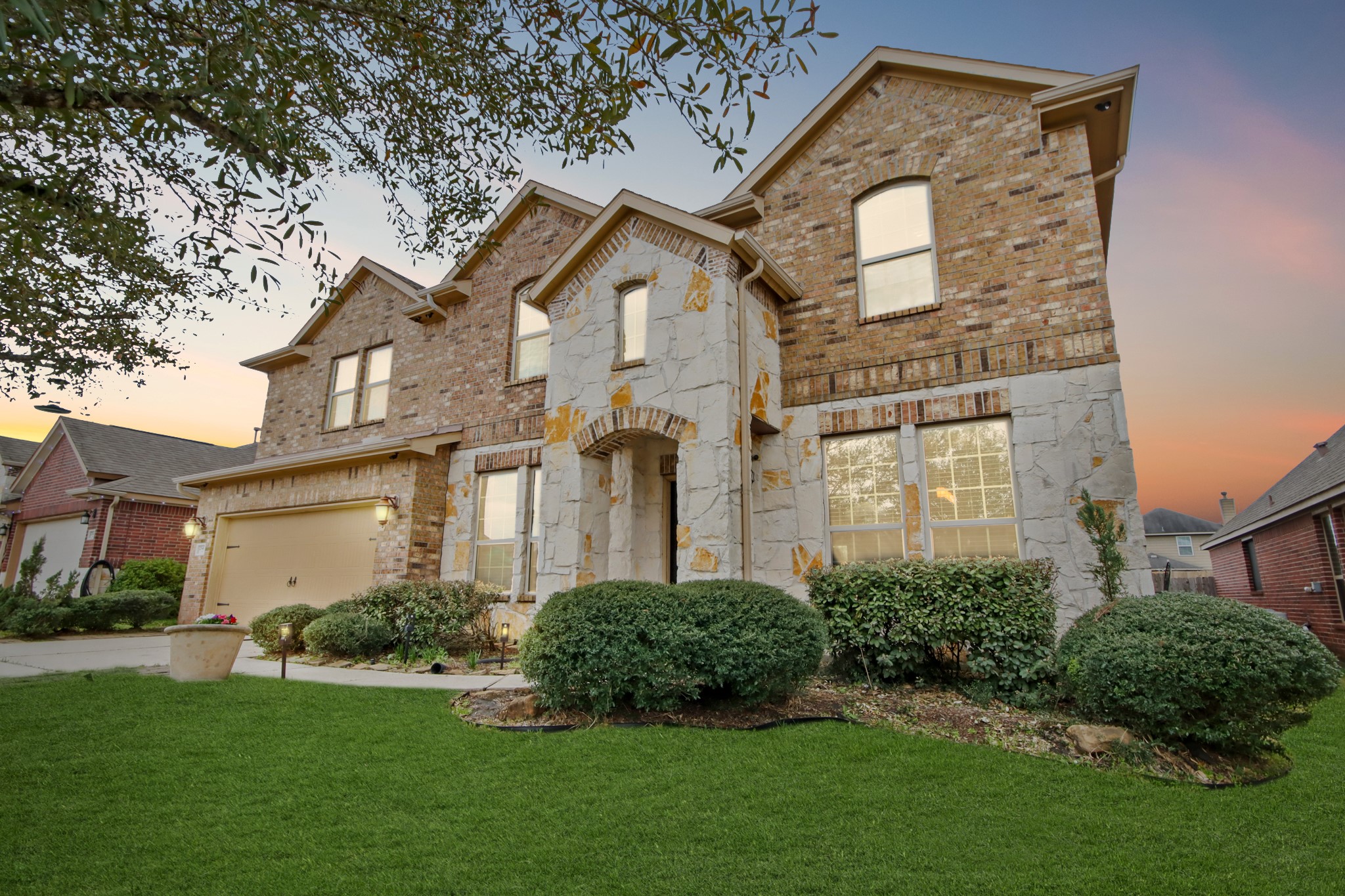 Eye-catching facade with elegant stone accents and mature landscaping creating strong curb appeal.