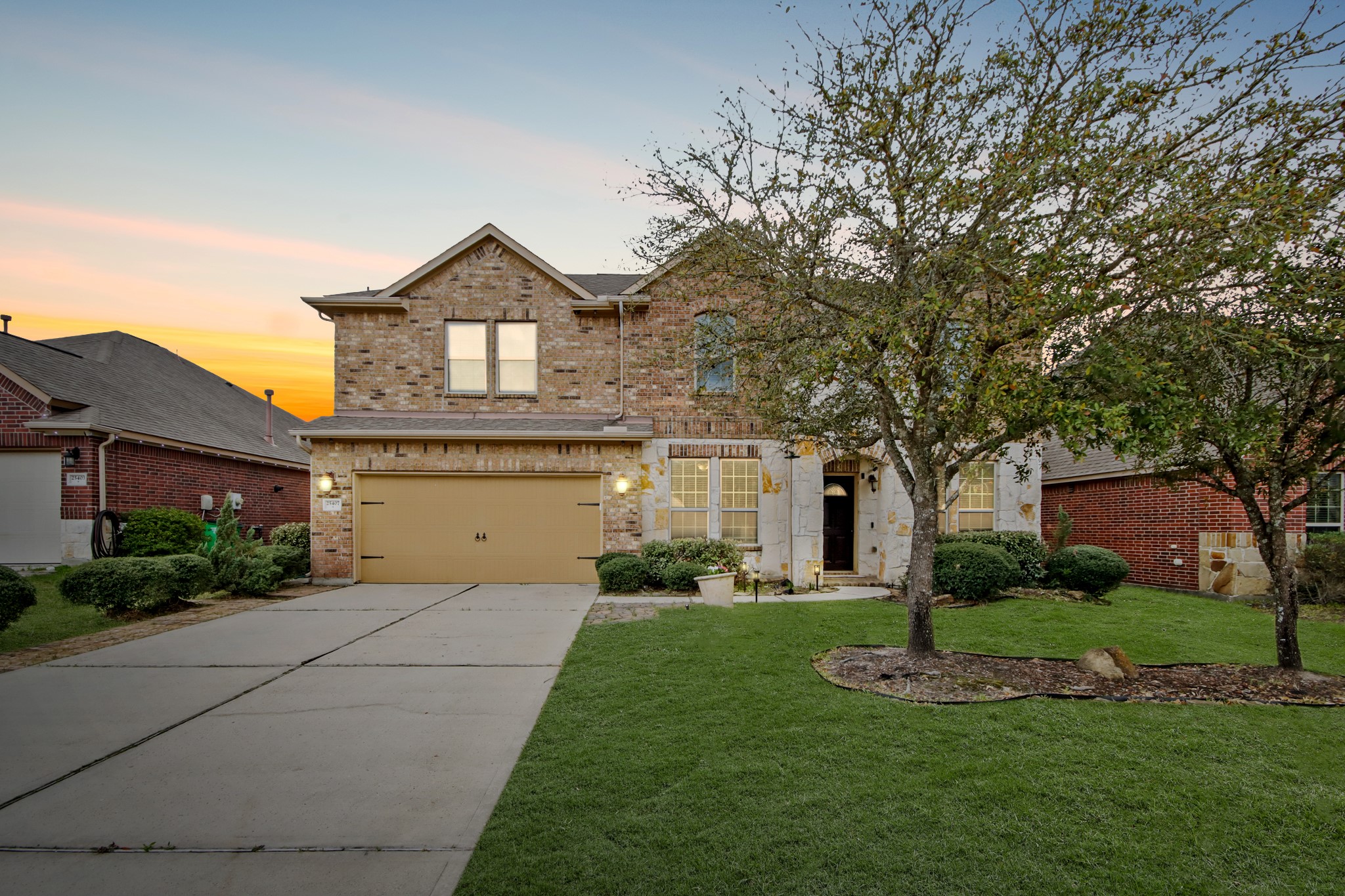 25407 Terrain Park Drive Spring, TX 77373 - Photo 2 of 33 Beautifully presented front exterior with lush lawn, and warm lighting that highlights the home’s inviting character.