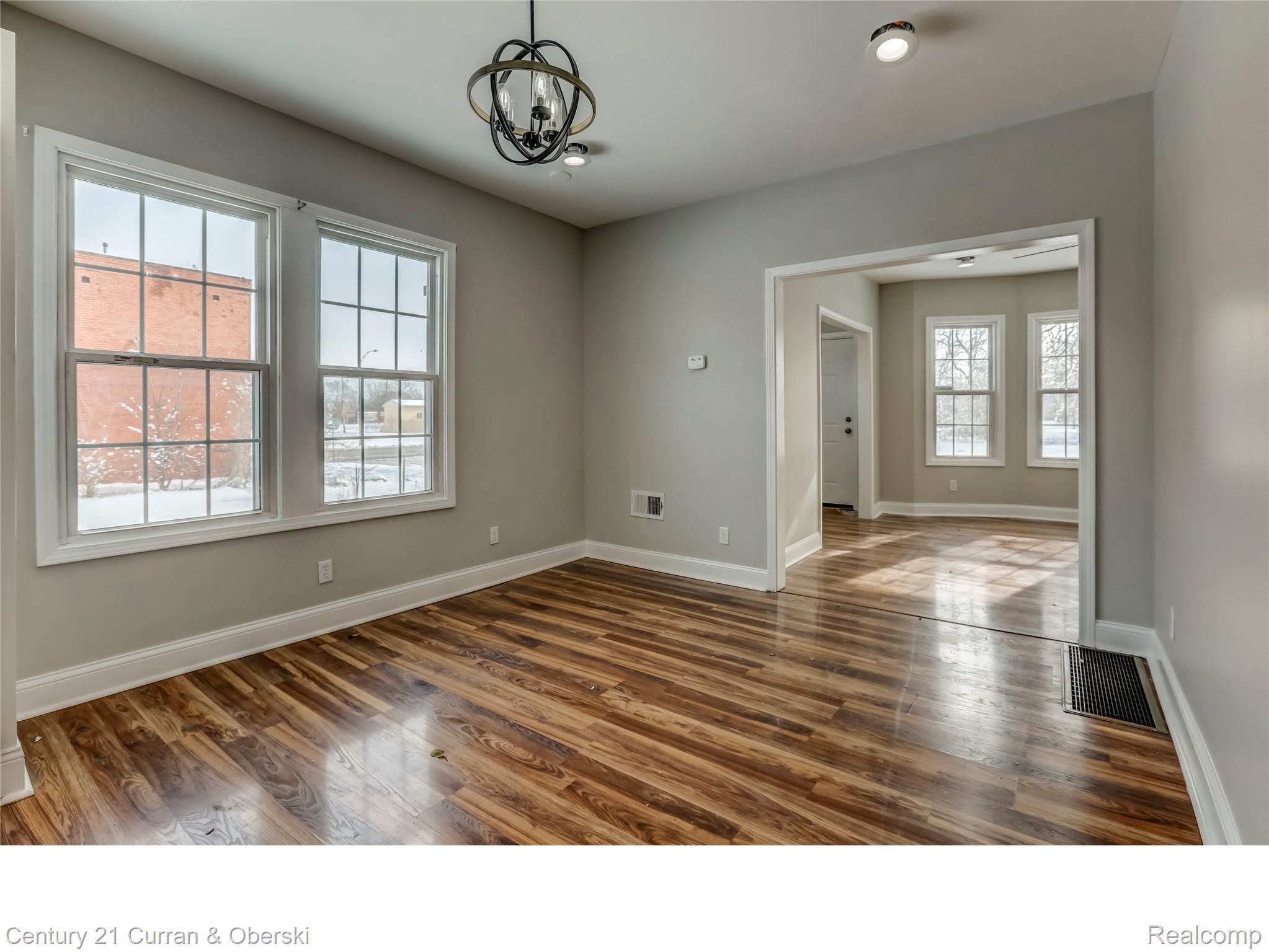 641 Josephine Street Detroit, MI 48202 - Photo 3 of 11 Room featuring wood-finish flooring, two large windows, a decorative ceiling light fixture, and recessed lighting