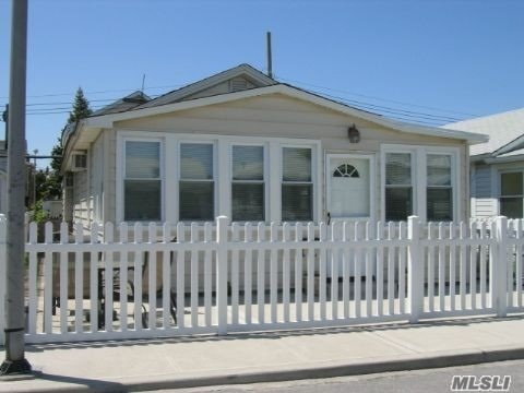 a front view of a house with white fence