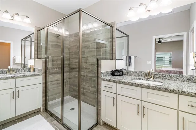 a bathroom with a shower sink and mirror