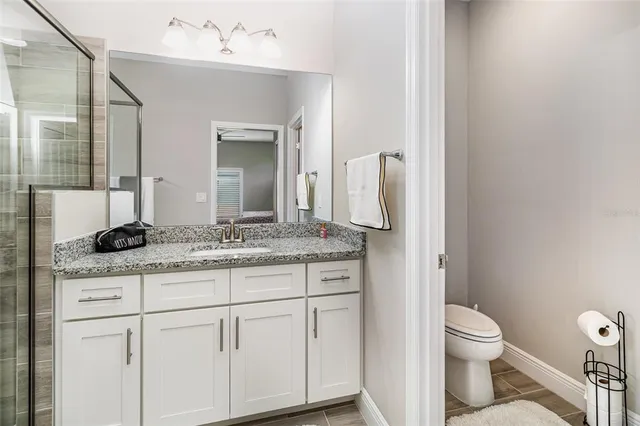 a bathroom with a granite countertop sink and a mirror
