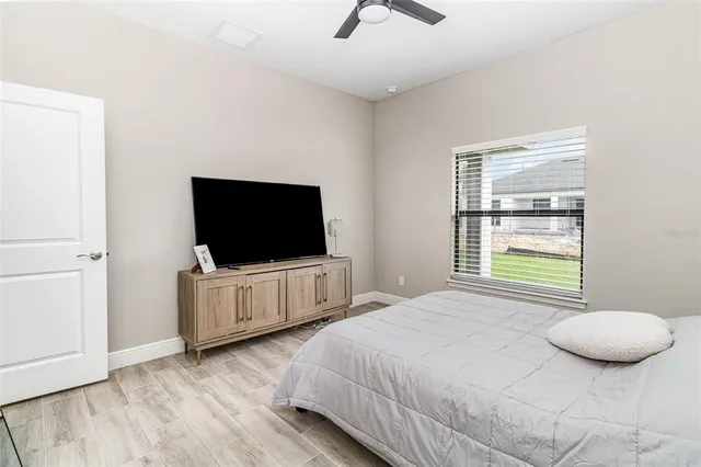 a bedroom with a flat screen tv and a window