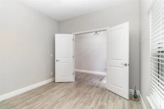 an empty room with wooden floor and a window