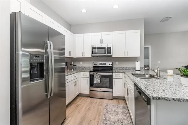 a kitchen with kitchen island granite countertop a stove sink and refrigerator