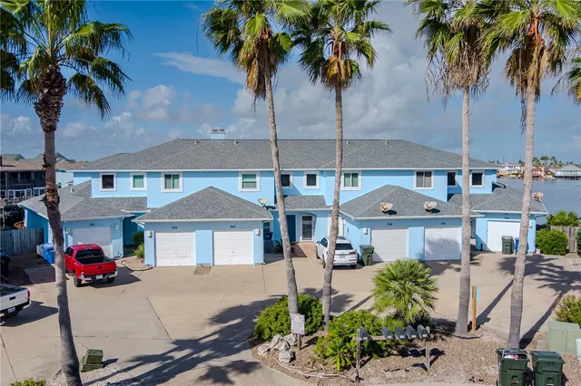 a front view of a house with garden space and palm tree