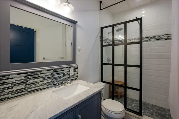 a bathroom with a toilet a sink and a mirror