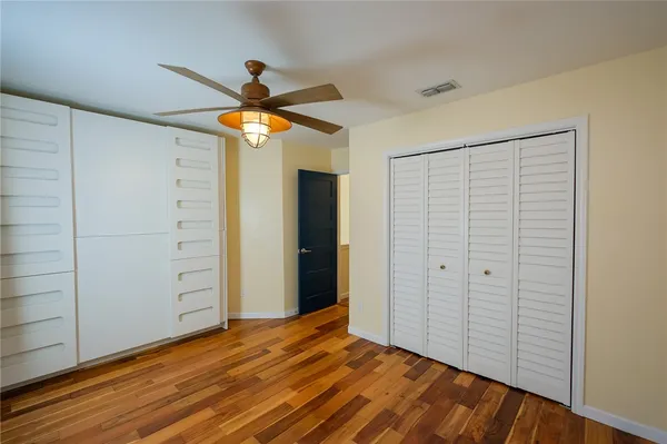 a view of empty room with wooden floor