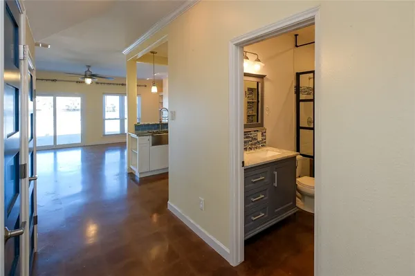 a view of a hallway with wooden floor and windows