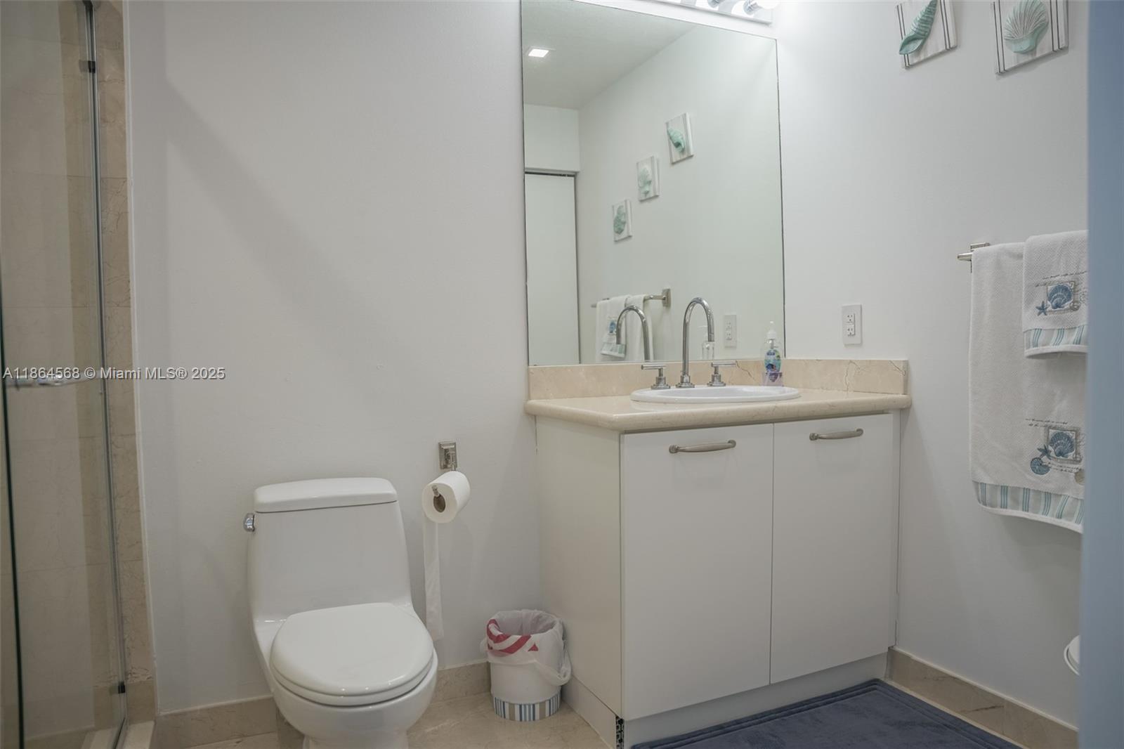 6515 Collins Avenue, Unit 1709 Miami Beach, FL 33141 - Photo 14 of 30 a white toilet sitting next to a bathroom sink