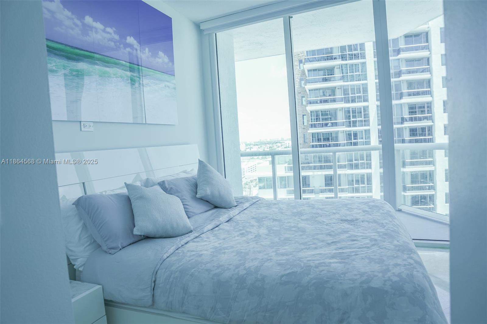 6515 Collins Avenue, Unit 1709 Miami Beach, FL 33141 - Photo 16 of 30 a large bed sitting in a bedroom next to a window