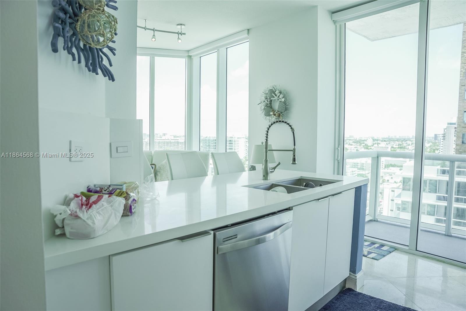 6515 Collins Avenue, Unit 1709 Miami Beach, FL 33141 - Photo 8 of 30 a kitchen with a sink and large window