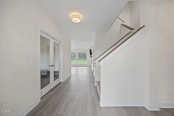 a view of a hallway with wooden floor and staircase