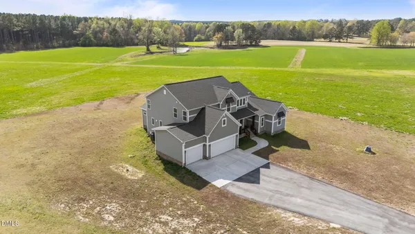 a view of a big house with a big yard and large trees