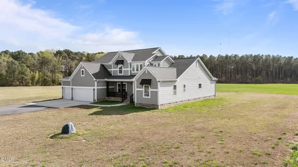 an aerial view of a house with a big yard next to a yard