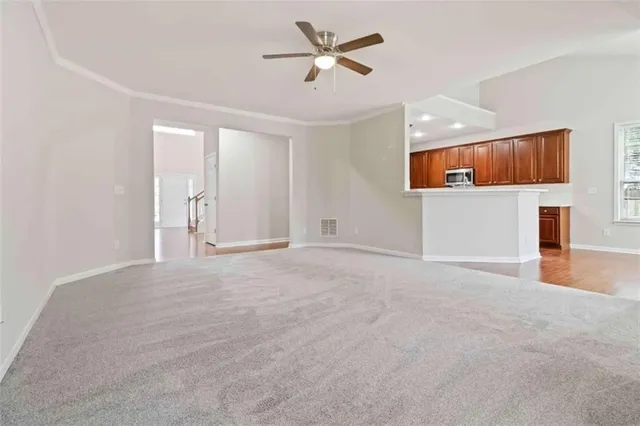 a view of a livingroom with a ceiling fan and entryway