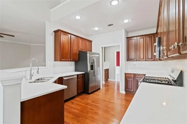 a kitchen with stainless steel appliances granite countertop a sink stove and refrigerator