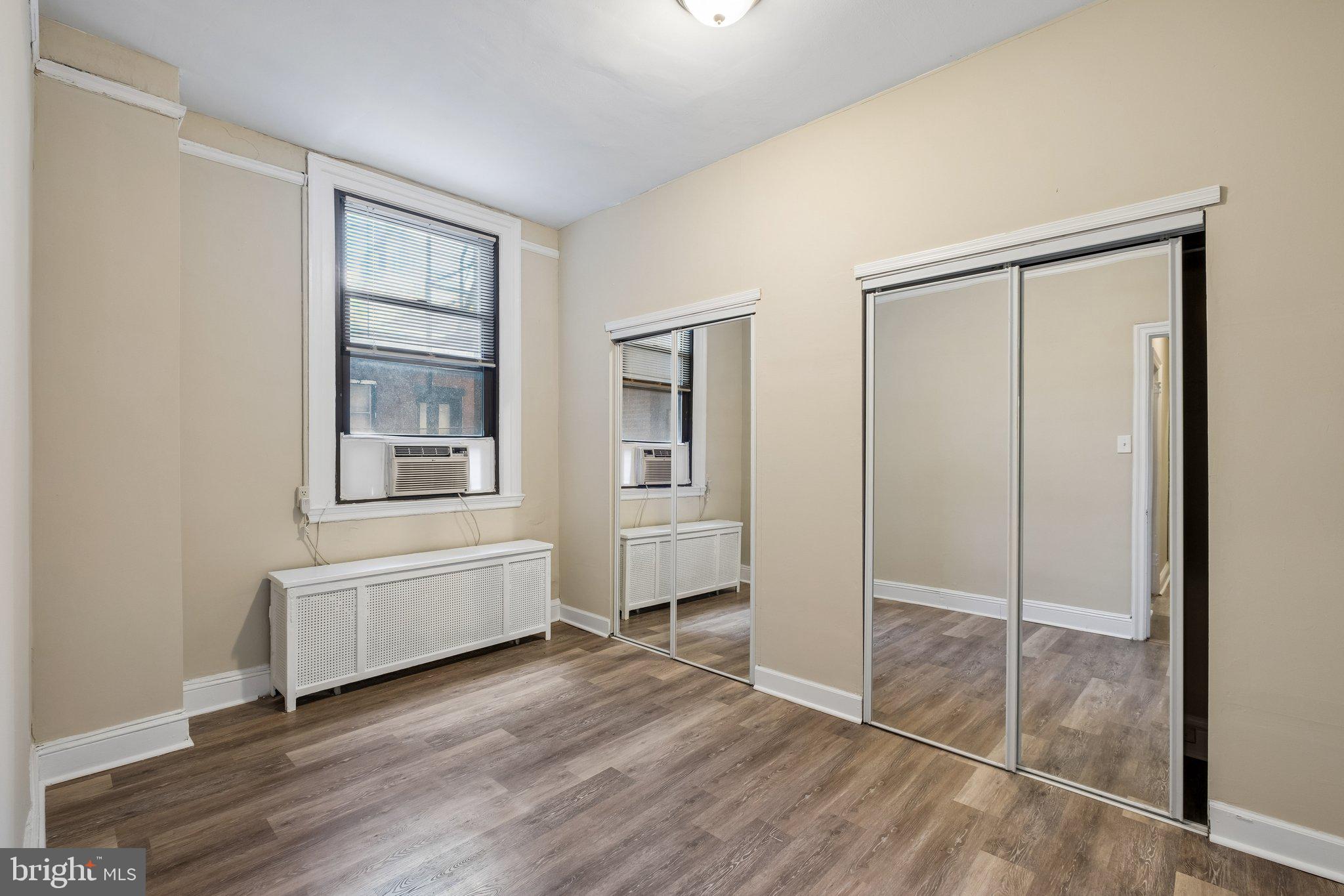 2031 Locust Street, Unit 101 Philadelphia, PA 19103 - Photo 13 of 23 a view of an empty room with wooden floor and a window