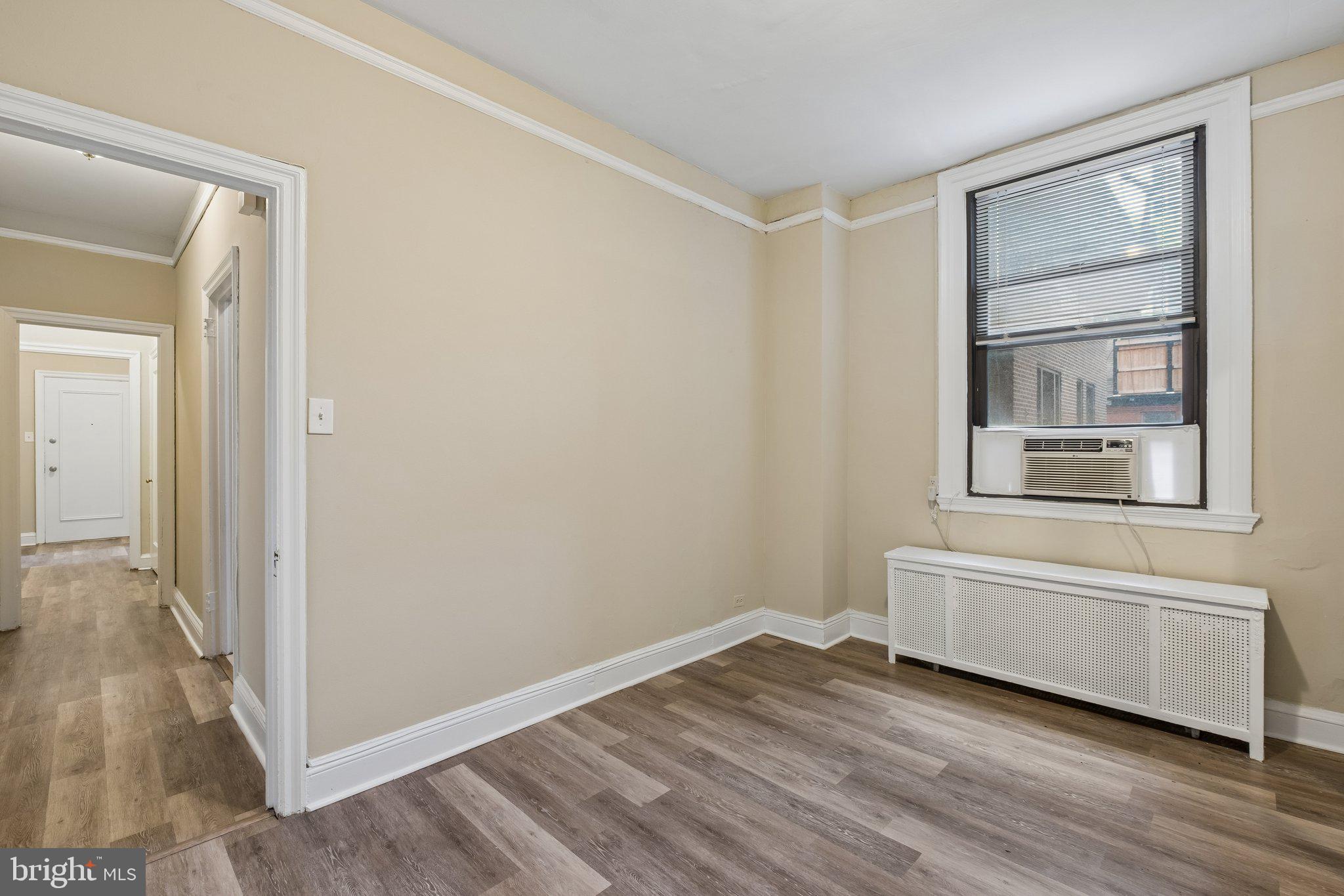 2031 Locust Street, Unit 101 Philadelphia, PA 19103 - Photo 14 of 23 a view of an empty room with wooden floor and a window