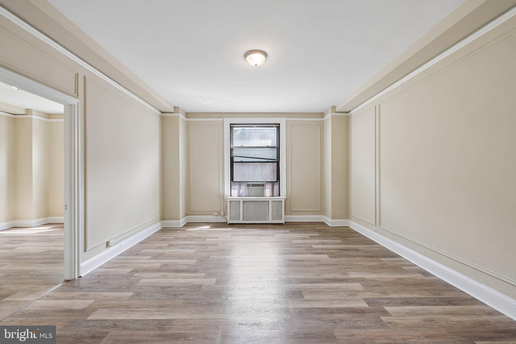 2031 Locust Street, Unit 101 Philadelphia, PA 19103 - Photo 2 of 23 a view of an empty room with wooden floor and window