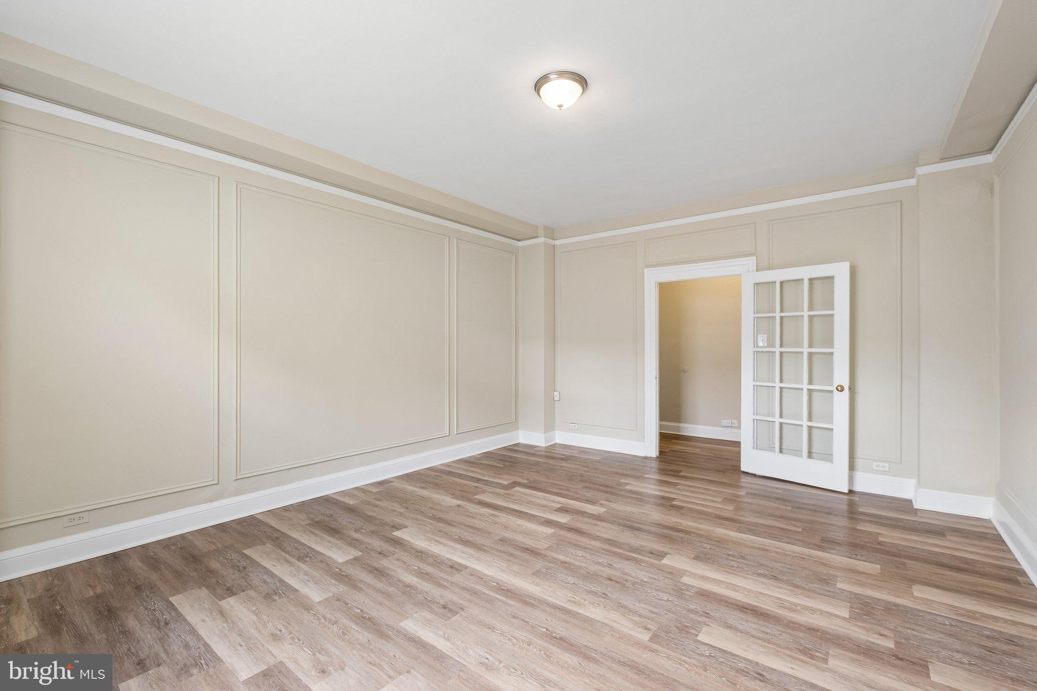 2031 Locust Street, Unit 101 Philadelphia, PA 19103 - Photo 3 of 23 a view of an empty room with wooden floor and a window
