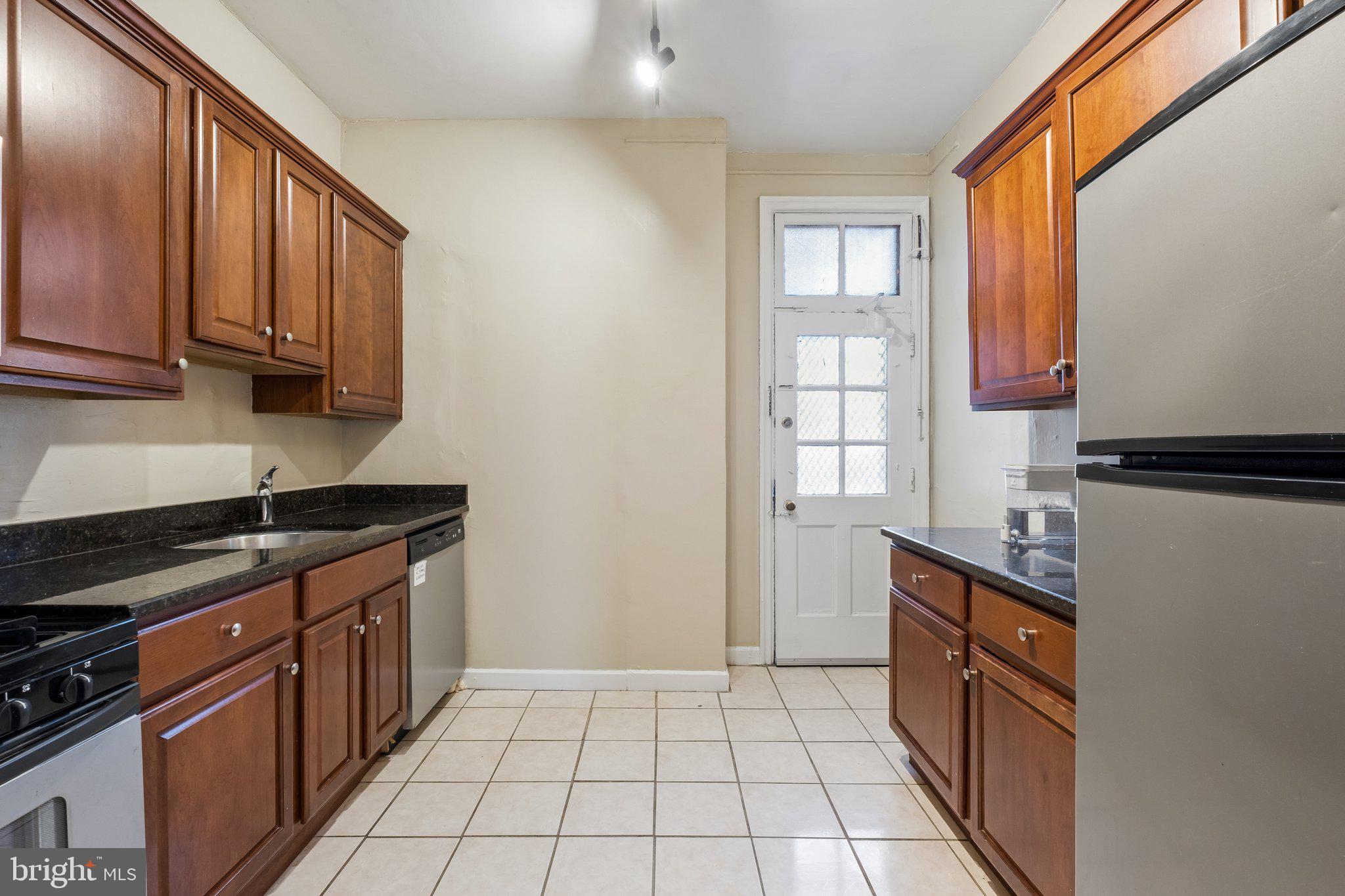 2031 Locust Street, Unit 101 Philadelphia, PA 19103 - Photo 4 of 23 a kitchen with granite countertop a stove sink and cabinets
