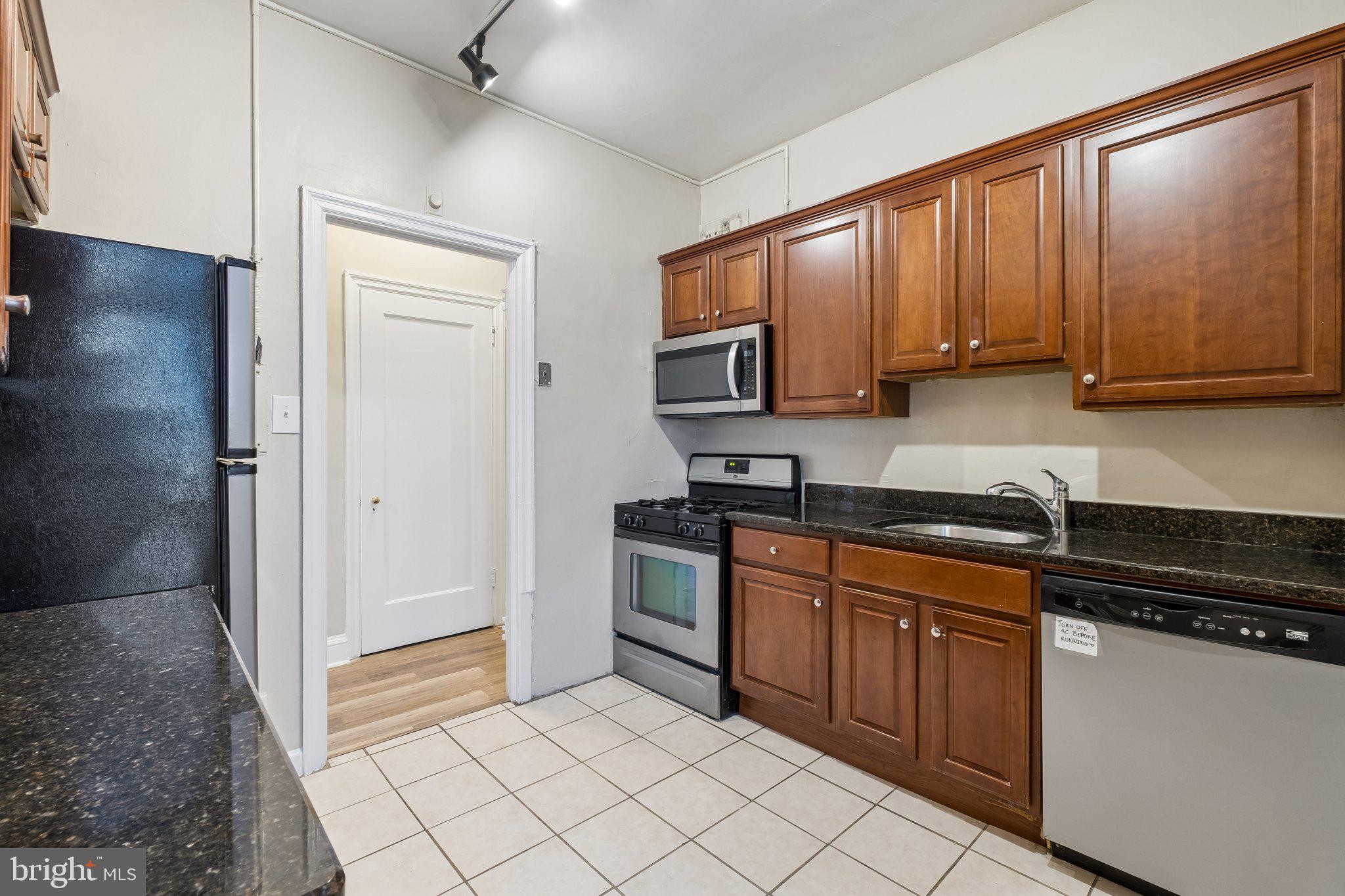 2031 Locust Street, Unit 101 Philadelphia, PA 19103 - Photo 5 of 23 a kitchen with stainless steel appliances granite countertop a stove a sink and a refrigerator
