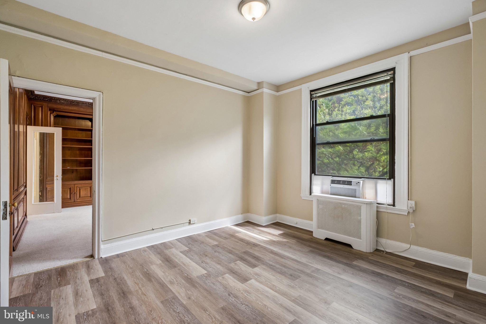 2031 Locust Street, Unit 101 Philadelphia, PA 19103 - Photo 7 of 23 an empty room with wooden floor and windows