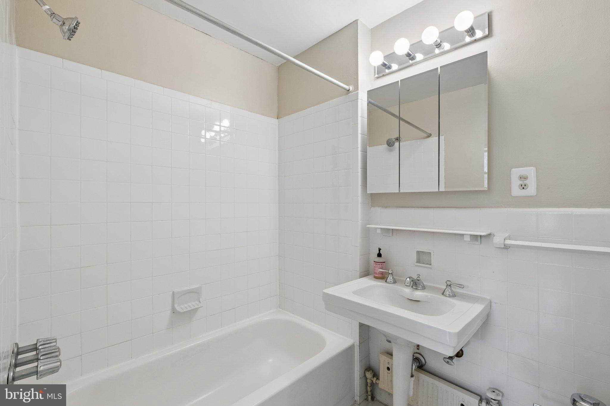 2031 Locust Street, Unit 101 Philadelphia, PA 19103 - Photo 9 of 23 a bathroom with a sink a mirror and a bathtub