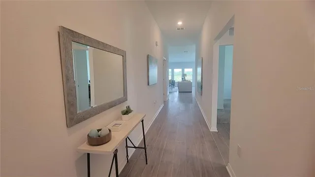 a view of a hallway with wooden floor