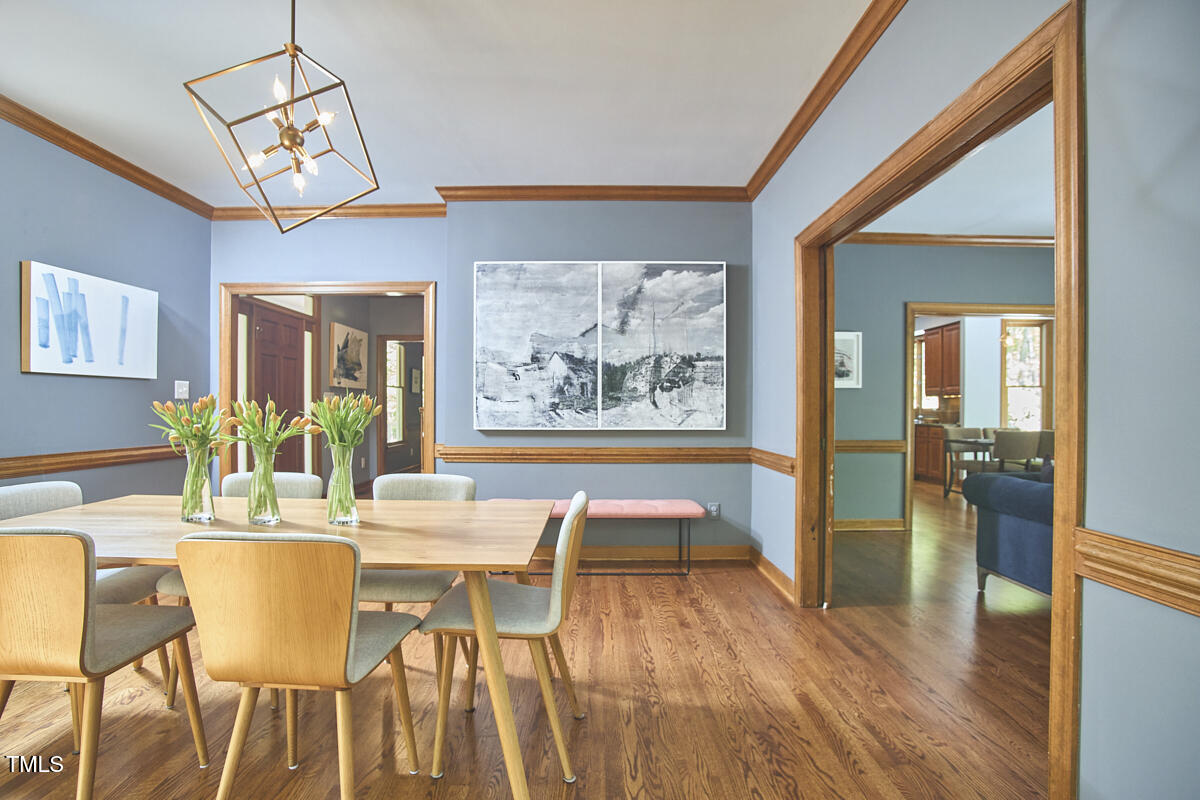 8407 Millers Bend Bahama, NC 27503 - Photo 18 of 77 a dining room with wooden floor a chandelier a glass table and chairs