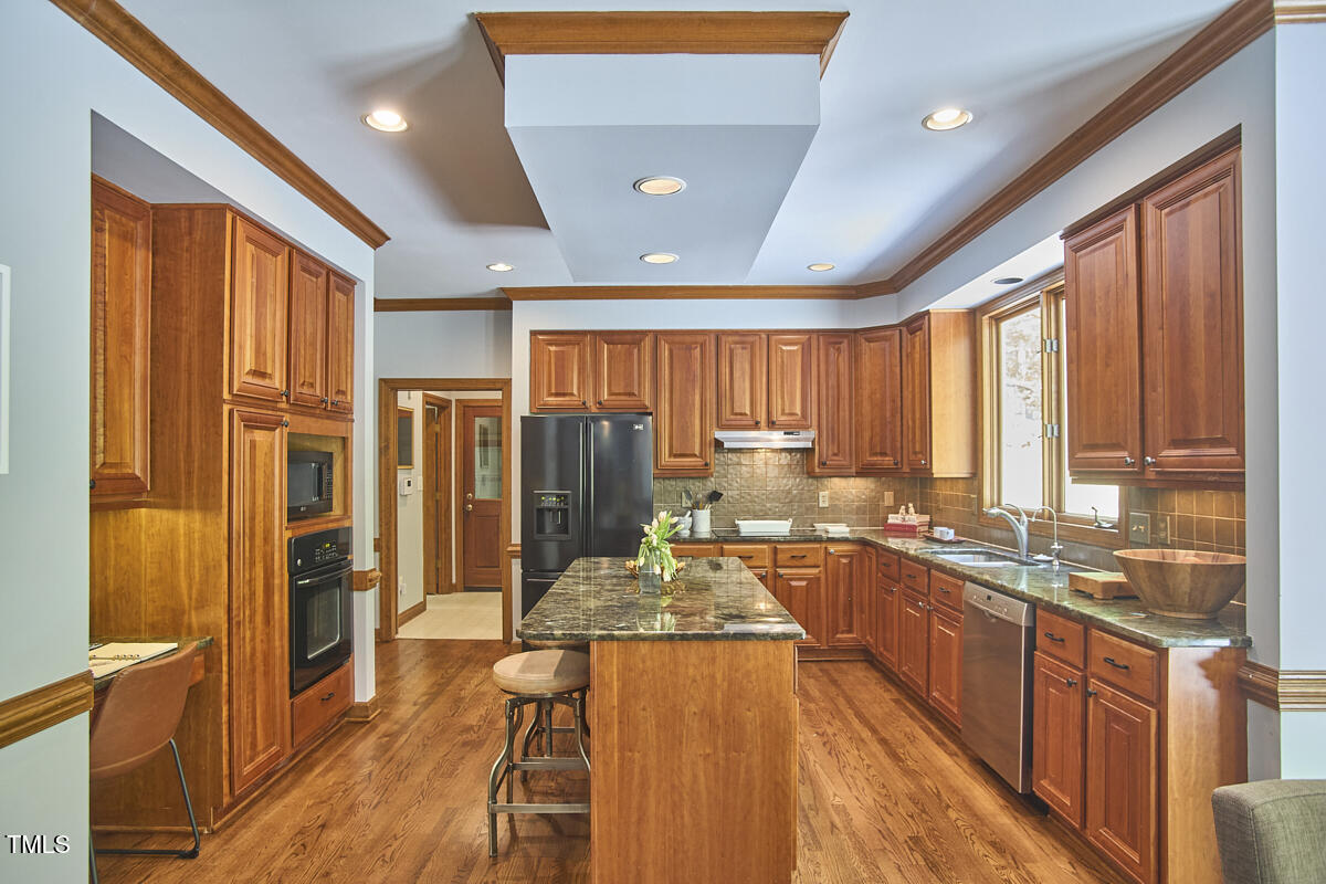 8407 Millers Bend Bahama, NC 27503 - Photo 30 of 77 a large kitchen with kitchen island granite countertop a large window and counter space