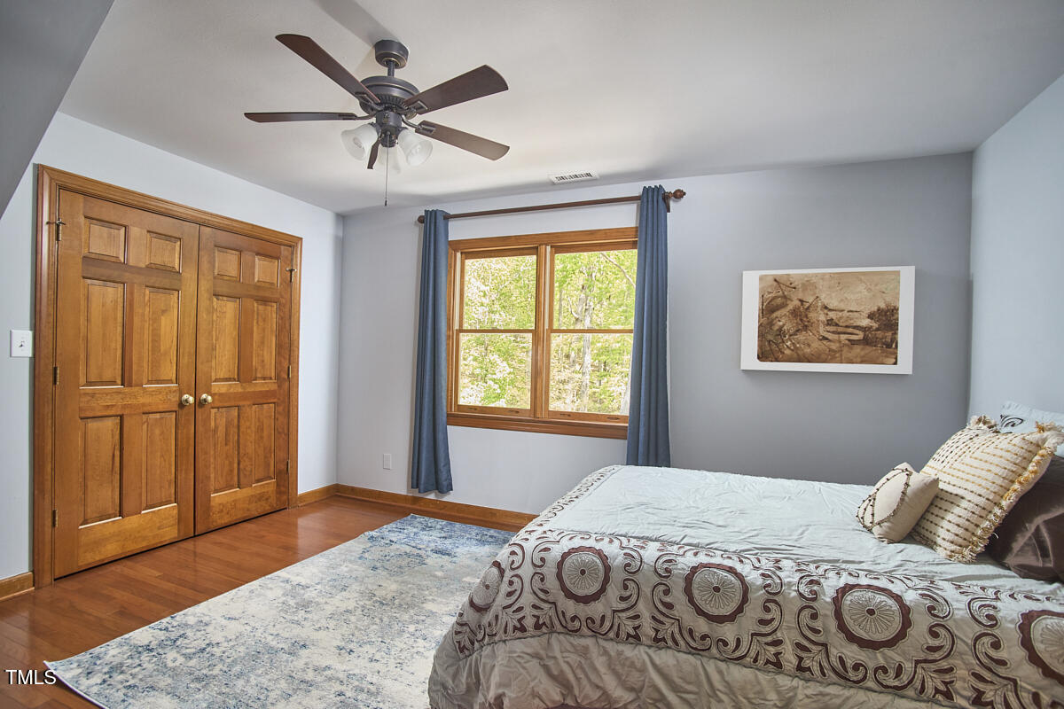 8407 Millers Bend Bahama, NC 27503 - Photo 54 of 77 a bedroom with a bed and wooden floor