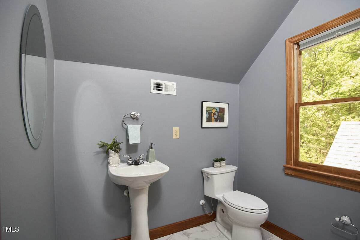 8407 Millers Bend Bahama, NC 27503 - Photo 64 of 77 a bathroom with a sink a toilet and mirror
