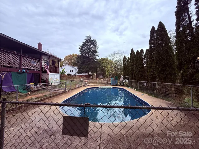 a view of a swimming pool with a patio and a yard
